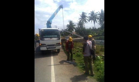 Petugas PLN memperbaiki tiang listrik di wilayah Aceh.