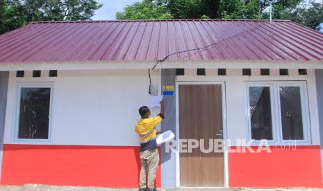 Petugas PLN mengecek meteran listrik yang dipasang di salah satu unit rumah yang dibangun khusus bagi korban bencana alam badai siklon seroja di perumahan Seroja di Kelurahan Manulai II, Kota Kupang, NTT, Rabu (23/3/2022).Pemerintah melalui Kementerian PUPR membangun 173 unit rumah bagi korban bencana siklon tropis seroja yang kini sudah 100 persen selesai pengerjaannya.