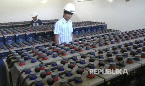 Petugas PLN tengah mengawasi isi baterai untuk pembangkit listrik