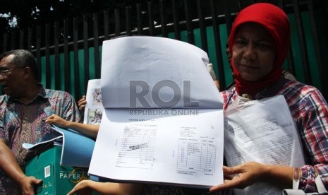   Petugas PN Jakarta Selatan bersama Indonesian Corruption Watch (ICW) menunjukkan laporan keuangan dana BOS dan BOP saat dieksekusi di SMP Negeri 67, Jakarta Selatan, Kamis (12/12).  (Republika/Yasin Habibi)