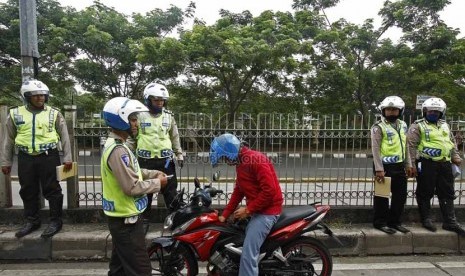  Petugas Polda Metro Jaya merazia kendaraan roda dua yang menerobos masuk ke jalur busway di kawasan Pasar Rumput, Manggarai, Jakarta Selatan, Jumat (22/3).  (Republika/Adhi Wicaksono)