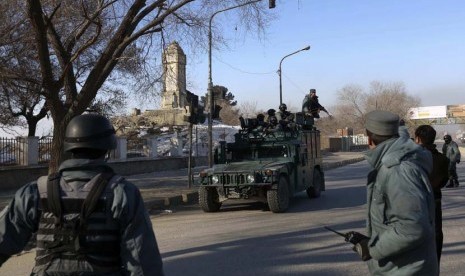   Petugas polisi Afghanistan lari ke markas polisi lalu lintas Kabul setelah diserang oleh gerilyawan di Kabul,Senin (21/1). (Reuters/Omar Sobhani)