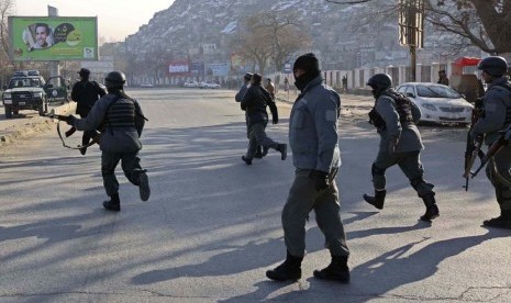   Petugas polisi Afghanistan lari ke markas polisi lalu lintas Kabul setelah diserang oleh gerilyawan di Kabul,Senin (21/1). (Reuters/Omar Sobhani)