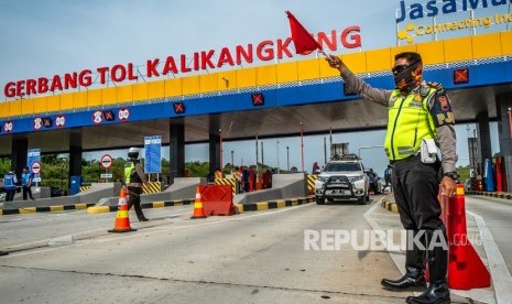 Petugas polisi berjaga saat pemberlakukan satu jalur (one way) di Tol Trans Jawa Km 414 Gerbang Tol Kalikangkung, Semarang, Jawa Tengah, Jumat (7/6/2019).