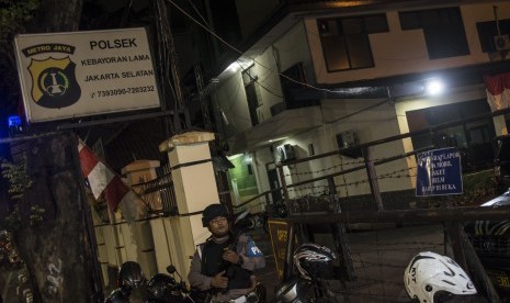 Petugas polisi bersenjata melakukan pengamanan pascapemasangan atribut ISIS di Polsek Kebayoran Lama, Jakarta, Selasa (4/7).