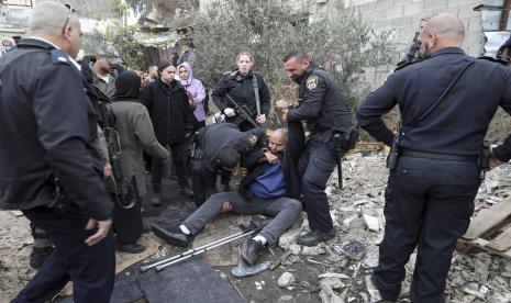  Tindakan Israel Batasi Kuasa Wakaf Islam di Masjid Al-Aqsa Dikecam. Foto:    Petugas polisi Israel menahan seorang pria Palestina selama protes mendukung keluarga Palestina yang berada di bawah ancaman penggusuran dari rumah lama mereka oleh pemukim Yahudi di lingkungan Yerusalem timur Sheikh Jarrah, Jumat, 17 Desember 2021.