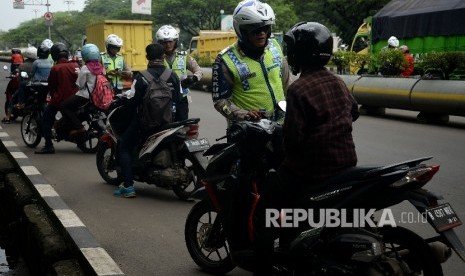 Petugas polisi melakukan penindakan terhadap pelanggar lalu lintas dengan mengunakan sistem E-Tilang saat razia kendaraan bermotor di Kawasan Kemayoran, Jakarta, Rabu (11/1).