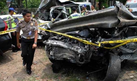  Petugas polisi memeriksa kondisi kendaraan Lancer IVO yang dikendarai putra bungsu Ahmad Dhani, Abdul Qodir Jaelani alias Dul yang ringsek akibat kecelakaan maut di Tol Jagorawi, Ahad (8/9).