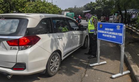 Petugas Polisi menghimbau pengguna kendaraan bermobil saat melakukan Pengawasan Pelaksanaan PSBB terkait penganggulan penyebaran COVID-19 bagi masyarakat yang akan masuk ke Ibu Kota Jakarta di perbatasan Depok-DKI Jakarta, Senin (13/4/2020). Dalam pengawasan tersebut petugas menghimbau bagi seluruh masyarakat untuk menggunakan masker saat berpergian serta mengatur posisi duduk dan pembatasan penumpang untuk kendaraan bermobil baik pribadi maupun angkutan umum.