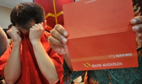 Petugas polisi menunjukkan barang bukti berupa buku tabungan Bank Mayapada dan tersangka kasus penggelapan ketika gelar kasus di Mapolrestabes Surabaya, Jatim, Ahad (15/4). 