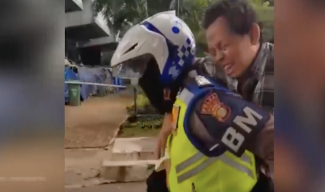 Petugas polisi tengah menolong penumpang Transjakarta yang terkena serangan jantung.