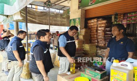 Petugas Polres Indramayu mengecek takaran Minyakita  di Pasar Jatibarang, Kabupaten Indramayu. 