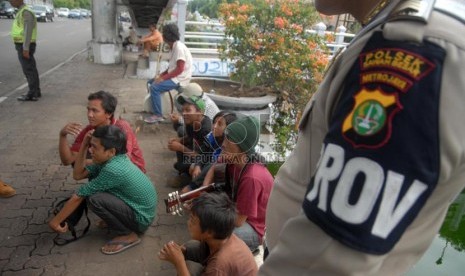 Petugas Polsek Metro Sawah Besar menertibkan sejumlah preman dan pengamen dalam razia kejahatan dalam bus di kawasan Pasar Baru, Jakarta Pusat, Rabu (13/11).   (Republika/Rakhmawaty La'lang)