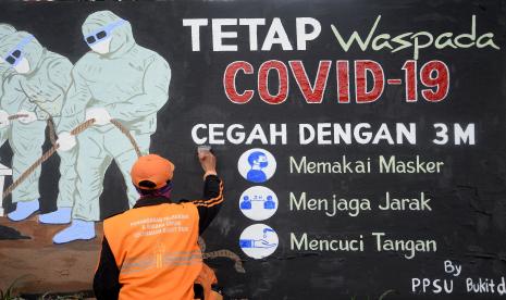 Petugas PPSU kelurahan Bukit Duri, Jakarta menyelesaikan pembuatan mural tentang Covid-19, Jakarta.