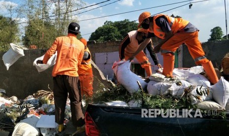 Petugas sedang membuang sampah ke tempat penampungan sampah sementara (ilustrasi) 