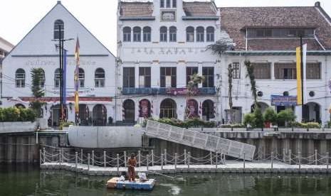 Petugas PPSU membersihkan sampah di Kali Besar, kompleks Kota Tua, Jakarta, Kamis (30/8). 