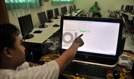 Petugas/proktor melakukan singkronisasi soal dari server pusat ke server sekolah untuk Ujian Nasional (UN) di SMA 70 Jakarta, Ahad (12/4).  (Republika/Rakhmawaty La'lang)