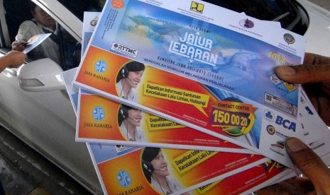 Petugas PT Jasa Marga cabang Jakarta-Tangerang saat membagikan peta mudik di gerbang tol Karang Tengah, Tangerang, Banten, Kamis (9/7).
