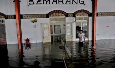  Petugas PT KAI berjalan melewati genangan air yang membanjiri Stasiun Tawang Semarang, Kamis (23/1).