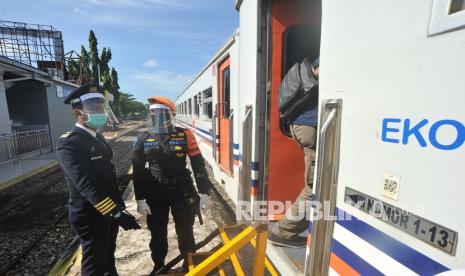 Petugas PT KAI bersama anggota kepolisian memantau Kereta Api Sibinuang sebelum berangkat, di Stasiun Tabing, Padang, Sumatera Barat, Sabtu (1/8/2020). PT KAI Divre II Sumbar kembali membuka perjalanan kereta api rute Padang - Naras (Pariaman) dengan memberlakukan protokol COVID-19 di antaranya penumpang diwajibkan menggunakan masker dan diimbau memakai pakaian lengan panjang serta menjaga jarak.