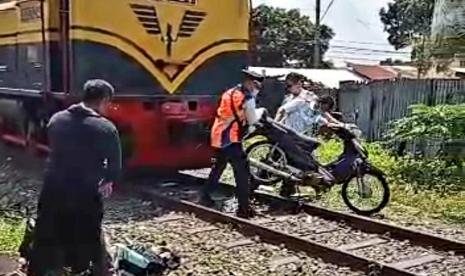 Petugas PT KAI membantu mengevakuasi sepedamotor yang tertabrak lokomotif kereta wisata di perlintasan sebidang tanpa palang pintunperlintasan, di Jalan Brigjend Sudiarto, lingkungan Losari Sawahan, Kelurahan Lodoyong, Kecamatan Ambarawa, Ahad (11/12) sekitar pukul 11.00 WIB.