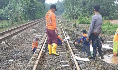 Petugas PT KAI membenahi jalur kereta api setelah terendam banjir di wilayah Ujungnegoro, Kabupaten Batang, Jawa Tengah, Ahad (27/1). Akibat banjir 11 perjalanan kereta sempat terhambat.