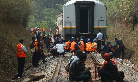 Petugas PT Kereta Api Indonesia (KAI) mengevakuasi rangkaian Kereta Lodaya rute Stasiun Solo Balapan-Bandung yang anjlok di KM 244+5/7 Desa Mekarsari, Kabupaten Tasikmalaya, Jawa Barat, Senin (5/10). 