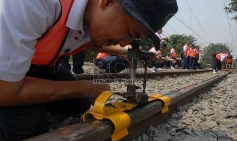   Petugas PT Kereta Api Indonesia (KAI) mengukur kerataan rel kereta api di kawasan Jatinegara,Jakarta,Kamis (6/9).   (Agung Fatma Putra)