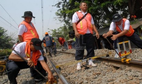  Petugas PT Kereta Api Indonesia (KAI) mengukur derajat kerataan rel kereta api di kawasan Jatinegara,Jakarta,Kamis (6/9).   (Agung Fatma Putra)