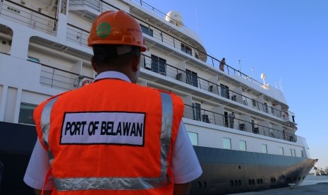 Petugas PT Pelindo I berada di dekat kapal pesiar MV. Noble Caledonia Sky yang bersandar di Terminal Penumpang Bandar Deli, di Belawan, Medan, Sumatera Utara, Rabu (12/10). 