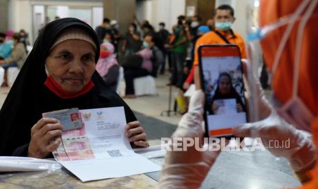 Petugas PT Pos Indonesia memotret wajah warga penerima Bantuan Sosial Tunai (BST) tahap VIII untuk kelengkapan administrasi pada proses penyaluran BST di Medan, Sumatera Utara, Jumat (13/11/2020). Realisasi kumulatif program Pemulihan Ekonomi Nasional (PEN) hingga 14 Desember mencapai Rp 481,61 triliun atau 69,3 persen dari pagu anggaran Rp 695,2 triliun. 