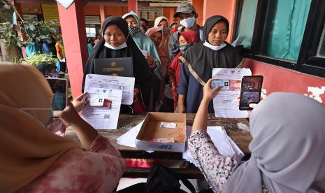 Petugas PT POS memotret warga penerima manfaat saat penyaluran bantuan sosial tunai (BST) untuk keluarga terdampak pandemi di halaman SD Negeri Kilasah, di Kasemen, Serang, Banten, Sabtu (13/2/2021). Dinsos Provinsi Banten mencatat terdapat 315.250 KK akan mendapat BST mulai Januari hingga April 2021 sebesar Rp300 ribu per-KK perbulan.