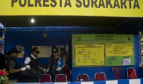 Petugas Puslabfor Polda Jateng memeriksa tempat kejadian perkara penembakan di Pos Pengamanan Lebaran Polresta Surakarta di Gemblegan, Solo, Jateng, Jumat (17/8).