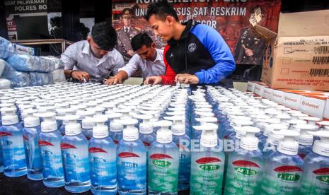 Petugas Reskrim Polres Bogor menata barang bukti dalam ungkap kasus penimbunan masker kesehatan dan cairan pembersih tangan (handsanitizer) di Polres Bogor, Cibinong, Kabupaten Bogor, Jawa Barat, Senin (9/3/2020).(Antara/Yulius Satria Wijaya)