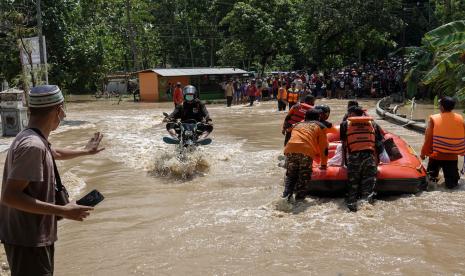 Petugas SAR gabungan menyeberangkan warga menggunakan perahu karet di ruas jalan nasional Jeruklegi-Kawunganten, yang terputus akibat banjir di Desa Jeruklegi Wetan, Jeruklegi, Cilacap, Jawa Tengah, Rabu (21/7/2021). Hujan deras menyebabkan banjir di beberapa wilayah di Kabupaten Cilacap, yang menggenangi tiga titik jalan nasional di kecamatan Jeruklegi dan menyebabkan arus kendaraan terhambat, serta merendam sejumlah rumah warga hingga ketinggian satu meter. (Ilustrasi)