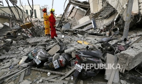 Petugas SAR mencoba mengevakuasi korban dari gedung 17 lantai yang rubuh akibat gempa di Taiwan, Sabtu (6/2).