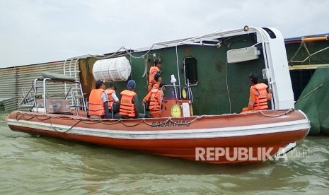 Petugas SAR Palembang memeriksa kapal Kahyong Utara yang terbalik di perairan sungai Musi, Tanjung Api Api, Banyuasin, Sumatera Selatan, Selasa (20/2). 