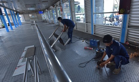 Petugas sarana dan prasarana Transjakarta memasang kursi tunggu penumpang di Halte Transjakarta Kampung Melayu, Jakarta, Jumat (26/5). 