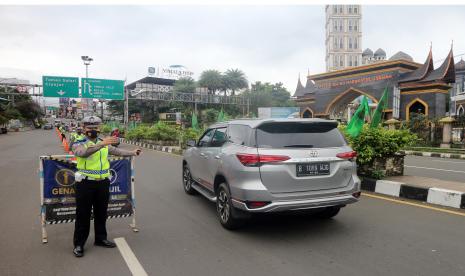 Petugas Sat Lantas Polres Bogor mengarahkan kendaraan wisatawan saat penyekatan kendaraan ganjil genap di jalur wisata Puncak, Gadog, Kabupaten Bogor, Jawa Barat, Senin (28/2/2022). Demi mencegah kepadatan kendaraan wisatawan di jalur wisata Puncak saat libur Isra Miraj,  sistem buka-tutup diterapkan di jalur menuju Puncak dari Cianjur.