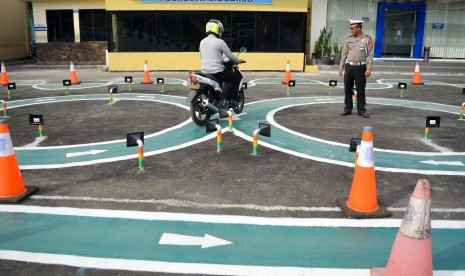 Petugas Satlantas mengawasi warga yang mengikuti ujian SIM (Surat Izin Mengemudi) C di Polresta Sidoarjo, Jawa Timur, Kamis (15/11/2018). 