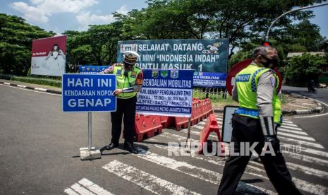 Petugas Satlantas Polres Metro Jakarta Timur bersiap bersiap melakukan pengendalian mobilitas ganjil genap untuk pengunjung TMII di Jalan Pintu 1 TMII, Jakarta Timur, Sabtu (18/9/2021). Direktorat Lalu Lintas (Ditlantas) Polda Metro Jaya memberlakukan kebijakan pembatasan mobilitas warga dengan sistem ganjil genap pada dua kawasan tempat wisata Taman Mini Indonesia Indah (TMII) dan Taman Impian Jaya Ancol pada hari Jumat, Sabtu, dan Minggu mulai pukul 12.00-18.00 WIB. 