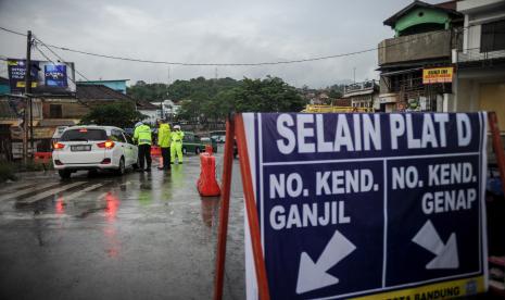 Petugas Satlantas Polresta Bandung memeriksa surat kesehatan pengendara saat pemberlakuan ganjil genap di pintu keluar tol Cileunyi, Kabupaten Bandung, Jawa Barat, Ahad (12/12/2021). Jelang Hari Raya Natal dan Tahun Baru 2022, Pemerintah Kabupaten Bandung bersama Polresta Bandung memperketat akses menuju kawasan wisata di Kabupaten Bandung dengan menerapkan ganjil genap guna mencegah munculnya klaster COVID-19.