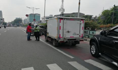 Petugas Satlantas Polrestro Jakbar menindak mobil boks yang melanggar kebijakan ganjil-genap di Jalan S Parman, Senin (10/8).