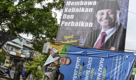 Petugas Satpol PP bersama Bawaslu menertibkan Alat Peraga Kampanye (APK) yang terpasang di Alun-alun Singaparna, Kabupaten Tasikmalaya, Jawa Barat, Selasa (13/10/2020). Penertiban APK pasangan calon Bupati dan Wakil Bupati Tasikmalaya itu karena pemasangan tidak sesuai dengan titik yang ditetapkan dalam peraturan KPU (PKPU). ANTARA FOTO/Adeng Bustomi/foc.