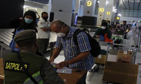 Petugas Satpol PP DKI Jakarta memeriksa dokumen kesehatan dan Surat Ijin Keluar Masuk (SIKM) Jakarta penumpang pesawat setibanya di Terminal 3 Bandara Soekarno Hatta, Tangerang, Banten, Rabu (27/5). Pakar Epidemiologi Universitas Indonesia Syahrizal Syarif memandang tak masalah jika pemerintah memutuskan menaikkan kapasitas penumpang pesawat dan bus menjadi 70 persen di tengah penularan corona. Syaratnya, protokol kesehatan pencegahan corona wajib diperketat.