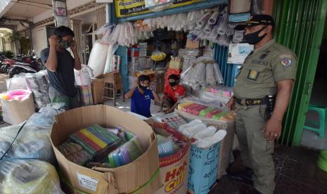 Petugas Satpol PP Kota Denpasar menegur pedagang agar menggunakan masker dalam sosialisasi protokol kesehatan COVID-19 di Pasar Kreneng, Denpasar, Bali, Jumat (28/8/2020). Pemerintah Provinsi Bali berencana memberikan sanksi denda bagi pelanggar protokol kesehatan COVID-19 mulai 7 September mendatang.