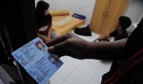 Petugas Satpol PP Kota Depok memeriksa identitas pasangan diluar nikah yang kedapatan berada dalam satu kamar saat razia di rumah kos kawasan Kelapa Dua, Depok, Jawa Barat, Selasa (12/5) malam.