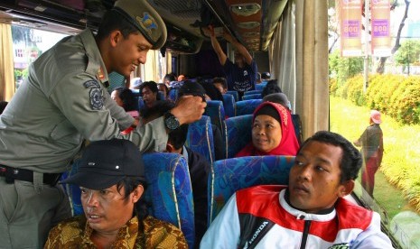 Petugas Satpol PP memeriksa kartu identitas berupa KTP penumpang bus dalam operasi Yustisi. (Ilustrasi)