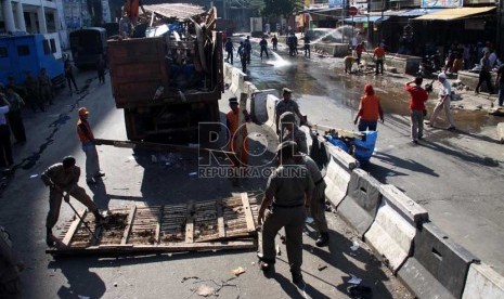  Petugas Satpol PP melakukan pembongkaran lapak PKL di kawasan Pasar Tanah Abang, Jakarta Pusat, Ahad (11/8). (Republika/ Yasin Habibi)