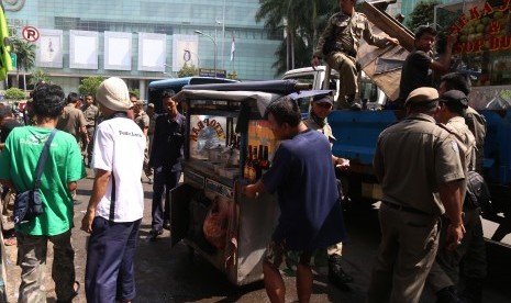 Petugas Satpol PP melalukan razia pedagang kaki lima (PKL) di Jalan Teluk Betung, Jakarta Pusat, Rabu (16/3).